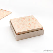 Eine quadratische, floral gemusterte Schachtel mit beigem Boden, teilweise geöffnet auf weißem Hintergrund - perfekt für die Herstellung von Geschenkverpackungen mit dem einfach zu verwendenden Alexandra Renke PAPPKit.