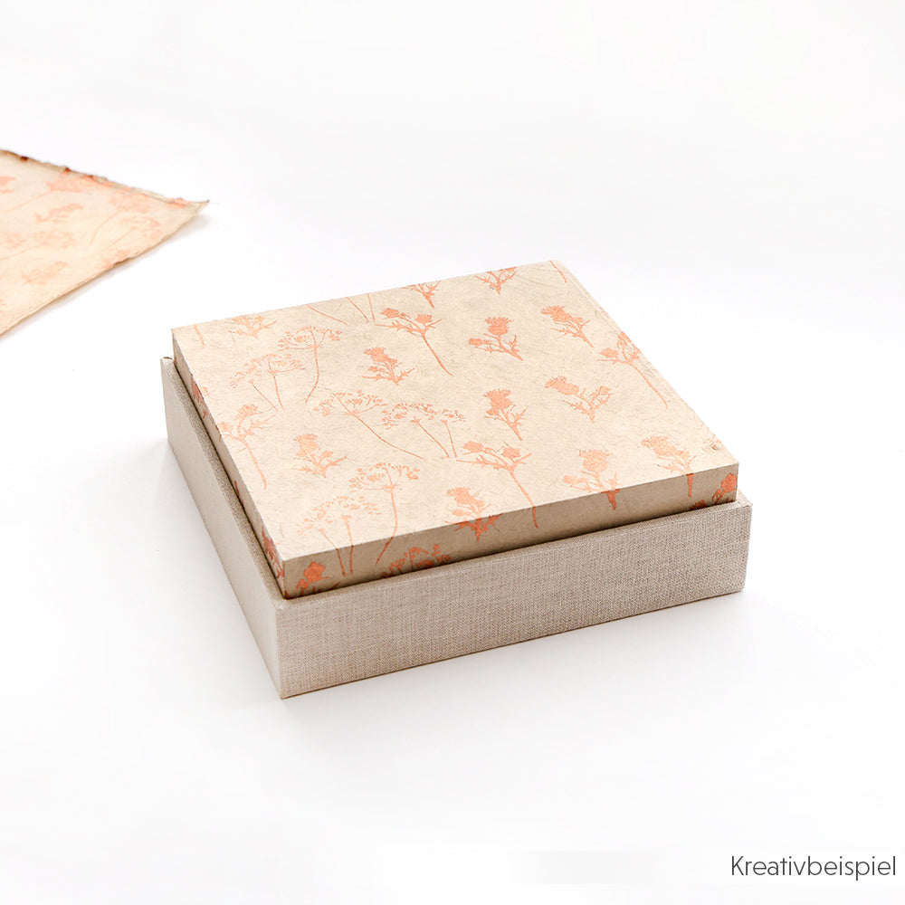 Eine quadratische, floral gemusterte Schachtel mit beigem Boden, teilweise geöffnet auf weißem Hintergrund - perfekt für die Herstellung von Geschenkverpackungen mit dem einfach zu verwendenden Alexandra Renke PAPPKit.