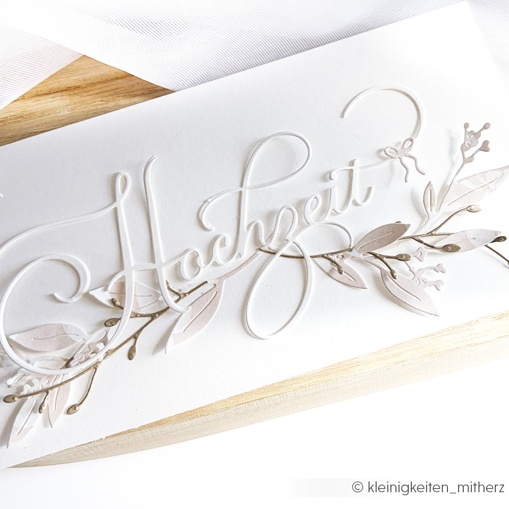 Weiße Hochzeitskarte von Alexandra Renke mit dem Schriftzug "Hochzeit" in eleganter Schrift, zarten floralen Verzierungen, verarbeitet mit hochwertigen Designpapieren und einer Motivstanze Hochzeit für exquisite Details.