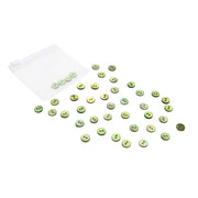 Kleine grüne Alexandra Renke Muschelknöpfe sind auf einer weißen Fläche verstreut, einige befinden sich in einem transparenten Ziplock-Beutel.