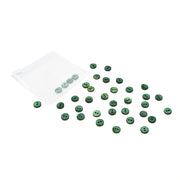 Alexandra Renke kleine grüne Muschelknöpfe sind in der Nähe eines transparenten Plastikbeutels auf weißem Hintergrund verstreut.