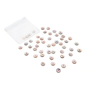 Ein kleiner weißer Beutel von Alexandra Renke mit rosa Akoya Muschelknöpfen, die auf weißem Hintergrund verstreut sind.