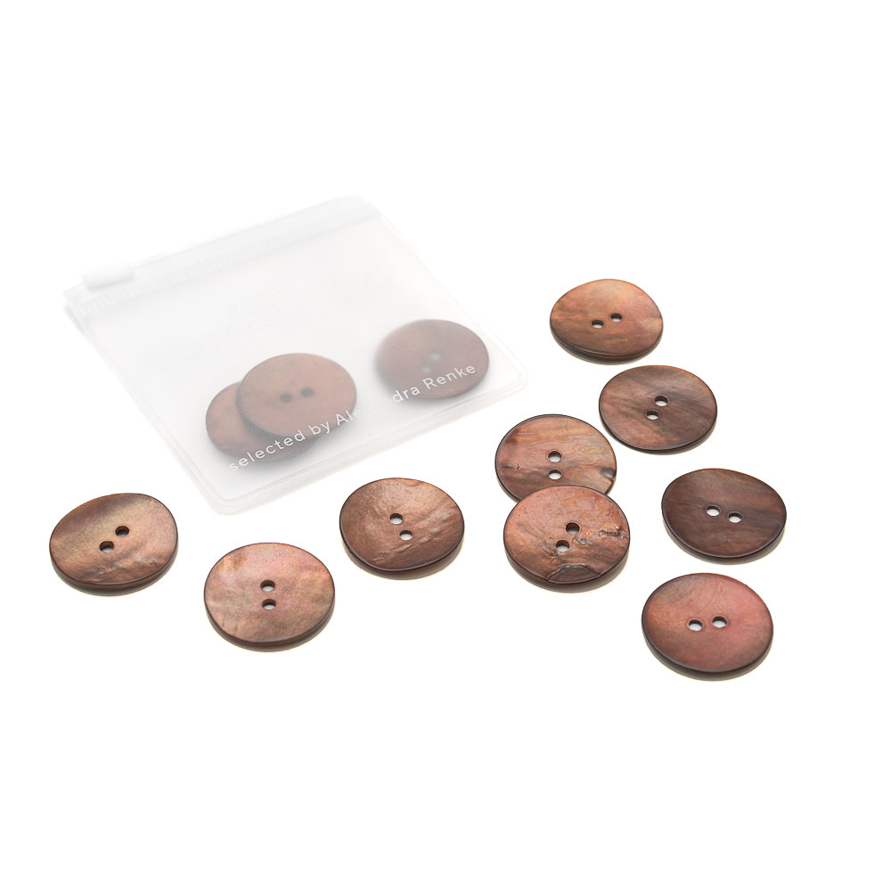 Zehn braune Zweiloch-Muschelknöpfe von Alexandra Renke, einige verstreut in der Nähe eines kleinen durchsichtigen Beutels, angeordnet auf weißem Hintergrund.