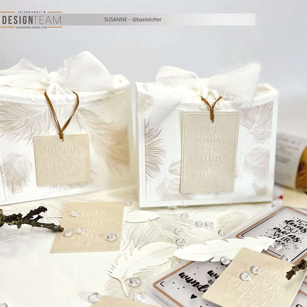 Zwei elegante weiße Geschenkboxen von Alexandra Renke mit geprägten Anhängern, Schleifenband und dekorativen Karten, hergestellt mit Stanzsystemen und Cut & Emboss Folder - ideal für kleine Botschaften auf hellem Untergrund.