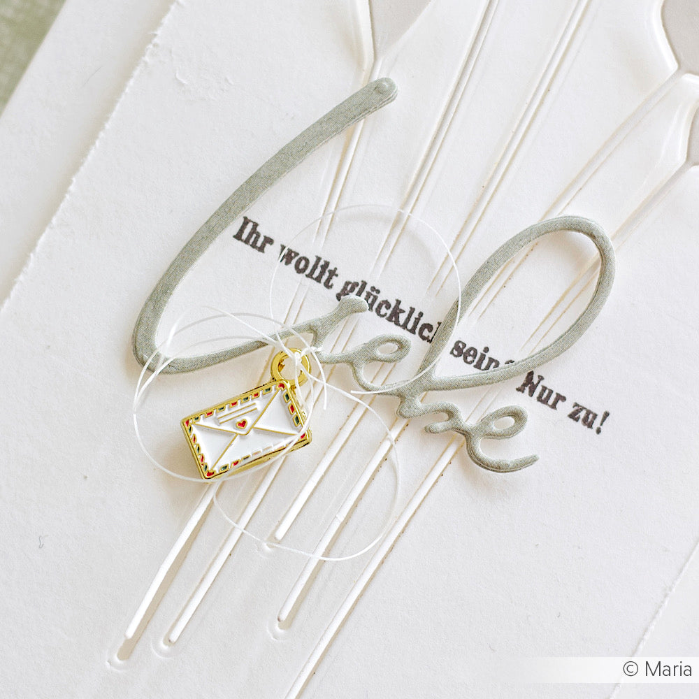 Eine handgefertigte Karte von Alexandra Renke mit dem Schriftzug "Love", deutschem Text und einem Charm Briefumschlag - einer Anhänger Metalllegierung - auf weißem Strukturpapier.