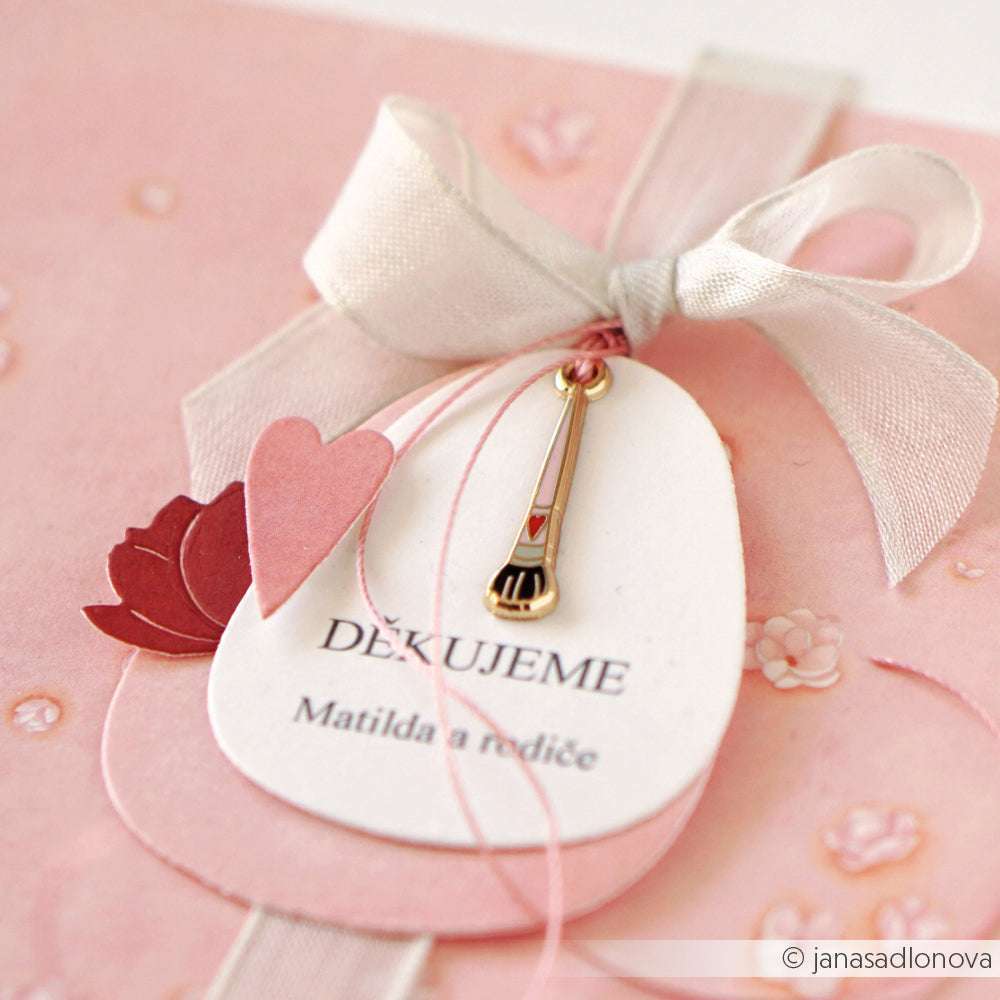 Die rosa-weiße Karte von Alexandra Renke mit Schleife, Herz und Sicherheitsnadel - beschriftet mit "Děkujeme Matilda a rodiče" - setzt einen charmanten Akzent bei Schmuck basteln oder Buchbindearbeiten.