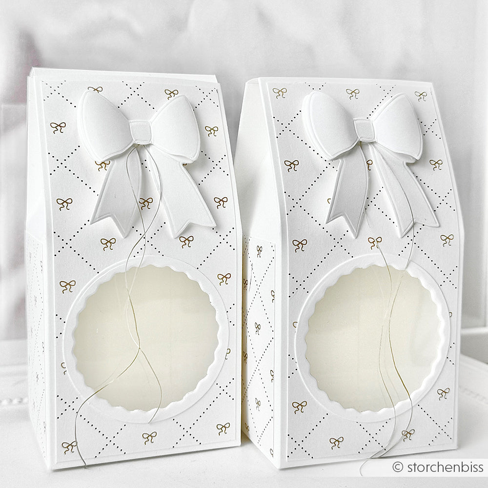 Zwei elegante weiße Geschenkschachteln mit Schleifen und klaren, runden Fenstern, verziert mit goldenen Akzenten - hergestellt mit Alexandra Renke Produkten für einen raffinierten Touch.