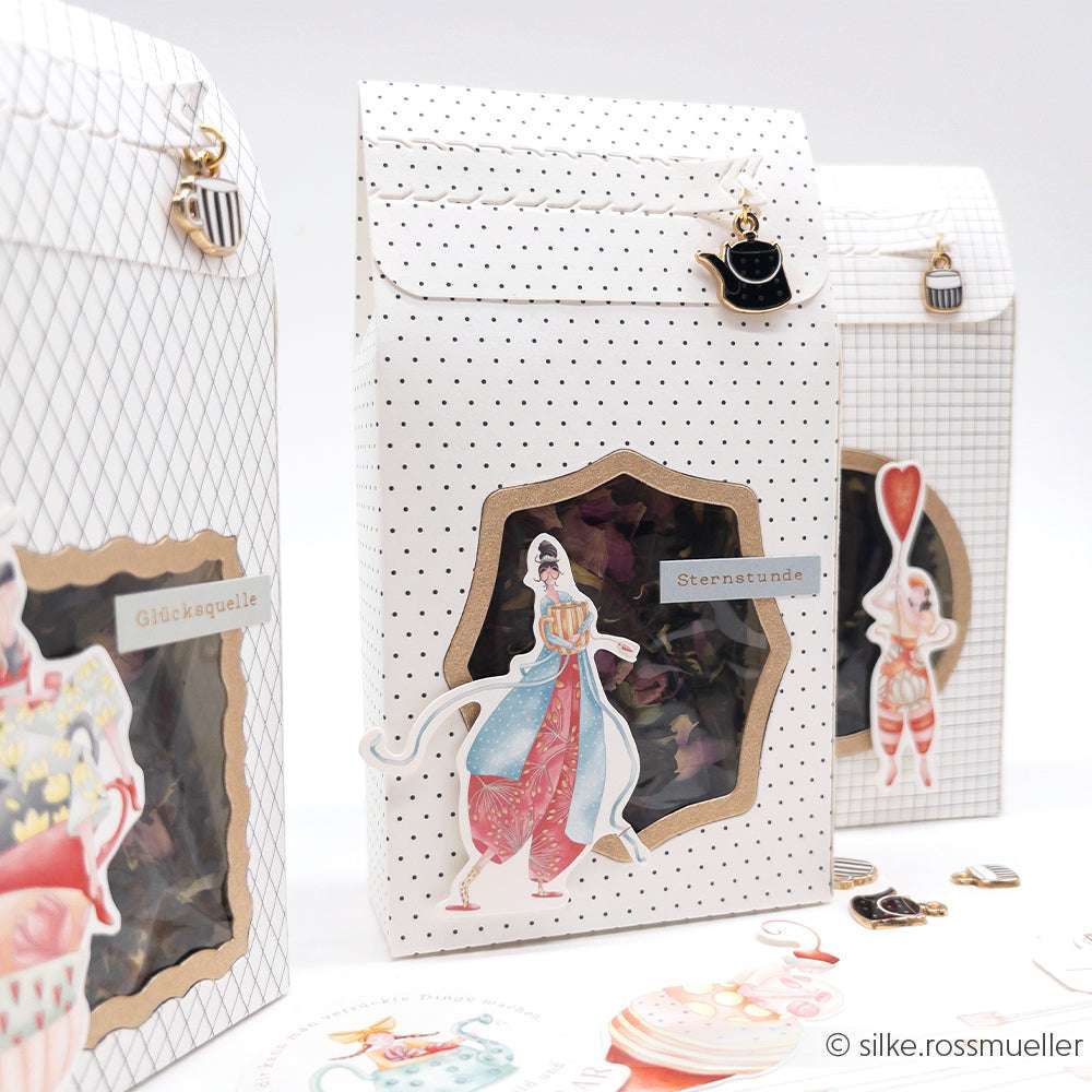 Drei dekorative Geschenkboxen von Alexandra Renke mit skurrilen Tee- und Zirkusmotiven und Fenstern - perfekt für die Präsentation von Kaffeezeit-Anhängern oder Ihrer Lieblingsschmuckanhänger.