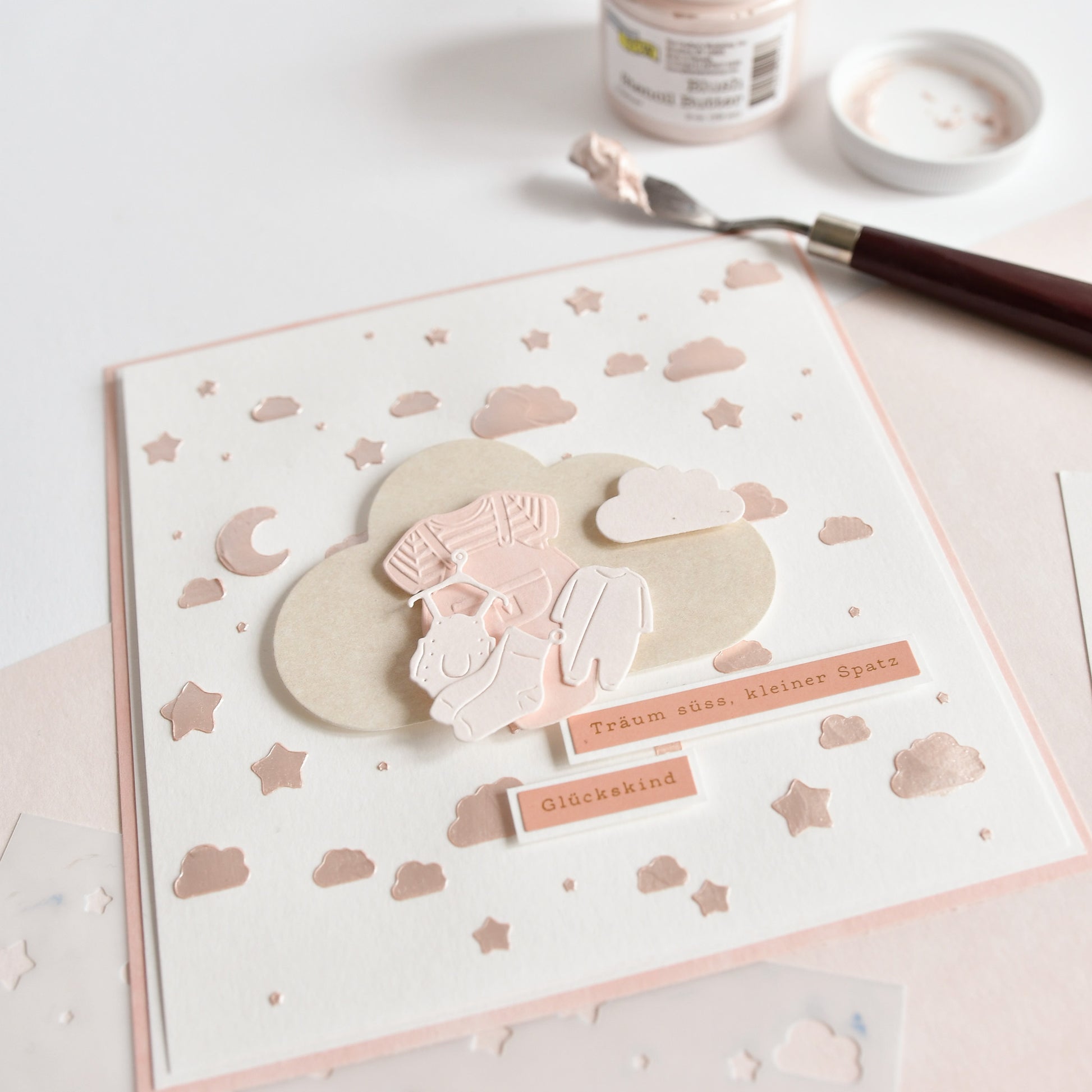Handgemachte Karte von Alexandra Renke, hergestellt mit einem Cut & Emboss Folder. Die Karte zeigt ein Kind und einen Hund auf einer Wolke, umgeben von Sternen, Mond und deutschem Text auf weißem Hintergrund.