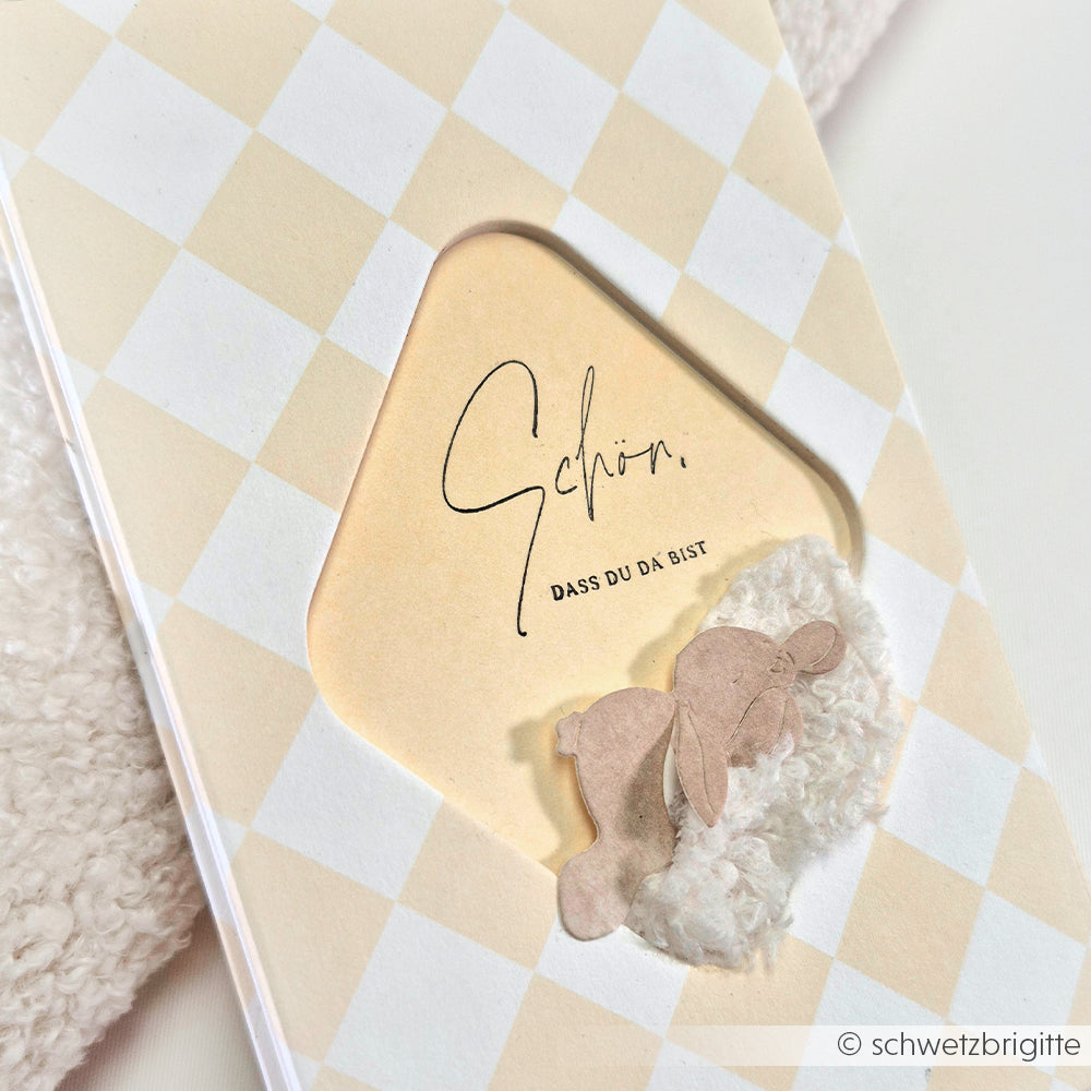 Grußkarte von Alexandra Renke mit beigefarbenem Karomuster, deutschem Text und zwei PAPPcut-Papierausschnitten auf einem flauschigen Patch - ideal für Buchbinden-Fans.