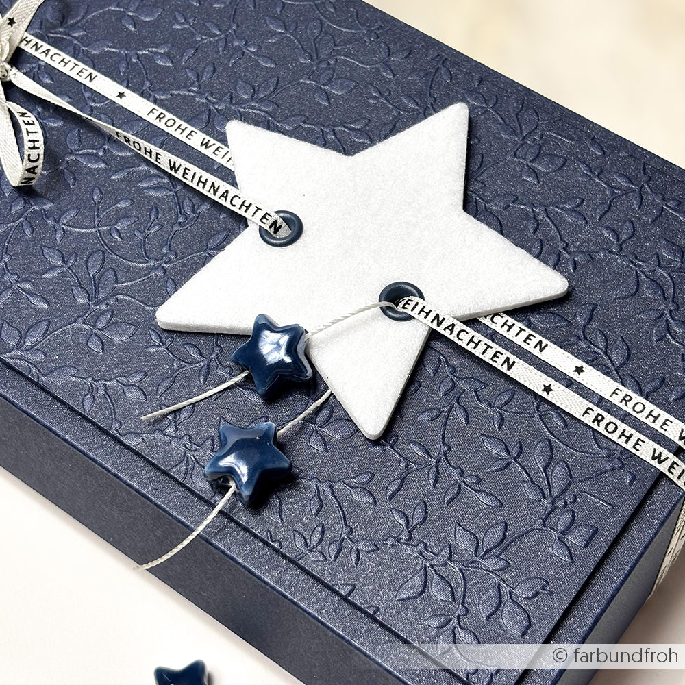 Dunkelblaue, strukturierte Geschenkbox von Alexandra Renke mit weißem PAPPcut-Stern aus Filz, Sternperlen und "Frohe Weihnachten"-Schleife - eine elegante Wahl zum Buchbinden oder Verschenken.
