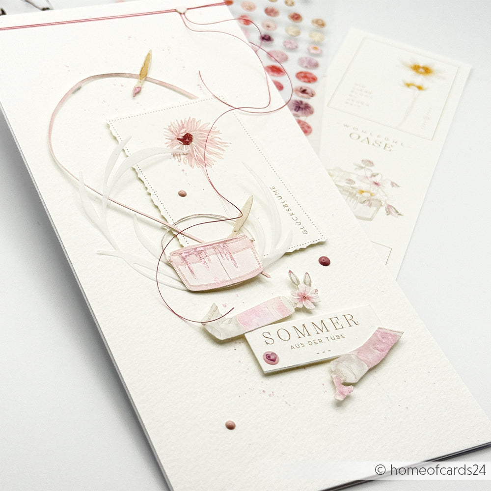 Handgefertigte Karte von Alexandra Renke mit Blumenmotiven, rosa Akzenten, Schleife, Rub-On-Details und dem Schriftzug „SOMMER AUS DER TUBE“ auf weißem Hintergrund – ideal für kreative Bastelprojekte.