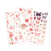 Drei Bögen mit rosa und lila Alexandra Renke Aufklebern mit Blumen, Schmetterlingen, Knöpfen, Faden und einer Nähmaschine - ideal für Bastelprojekte oder in Kombination mit Transferfolien für kreative Bastelarbeiten.