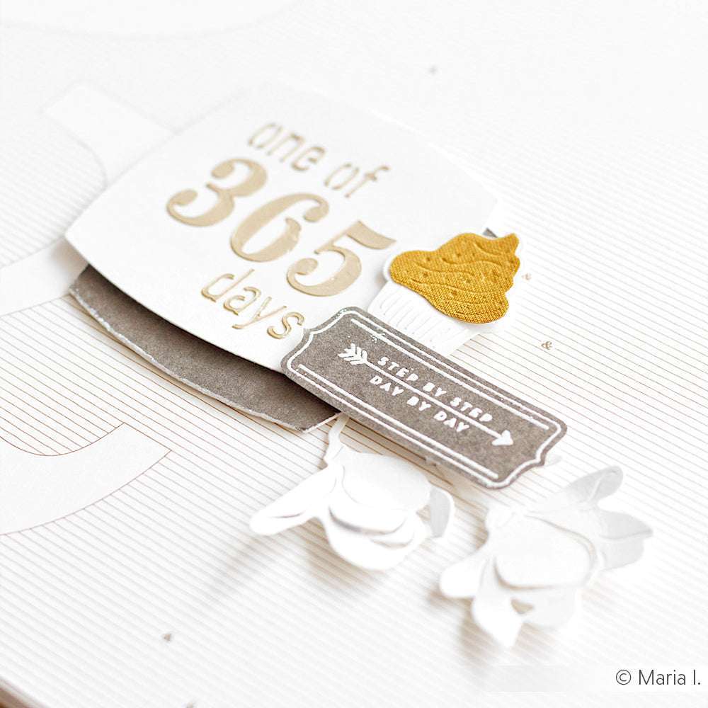Eine weiß-goldene Karte von Alexandra Renke markiert einen von 365 Tagen, verziert mit verschnörkelten Details und einem goldenen Kacka-Emoji - ideal zur Verwendung mit Ihrem Lieblings-Clear Stamp oder Acrylblock für zusätzliche Kreativität.