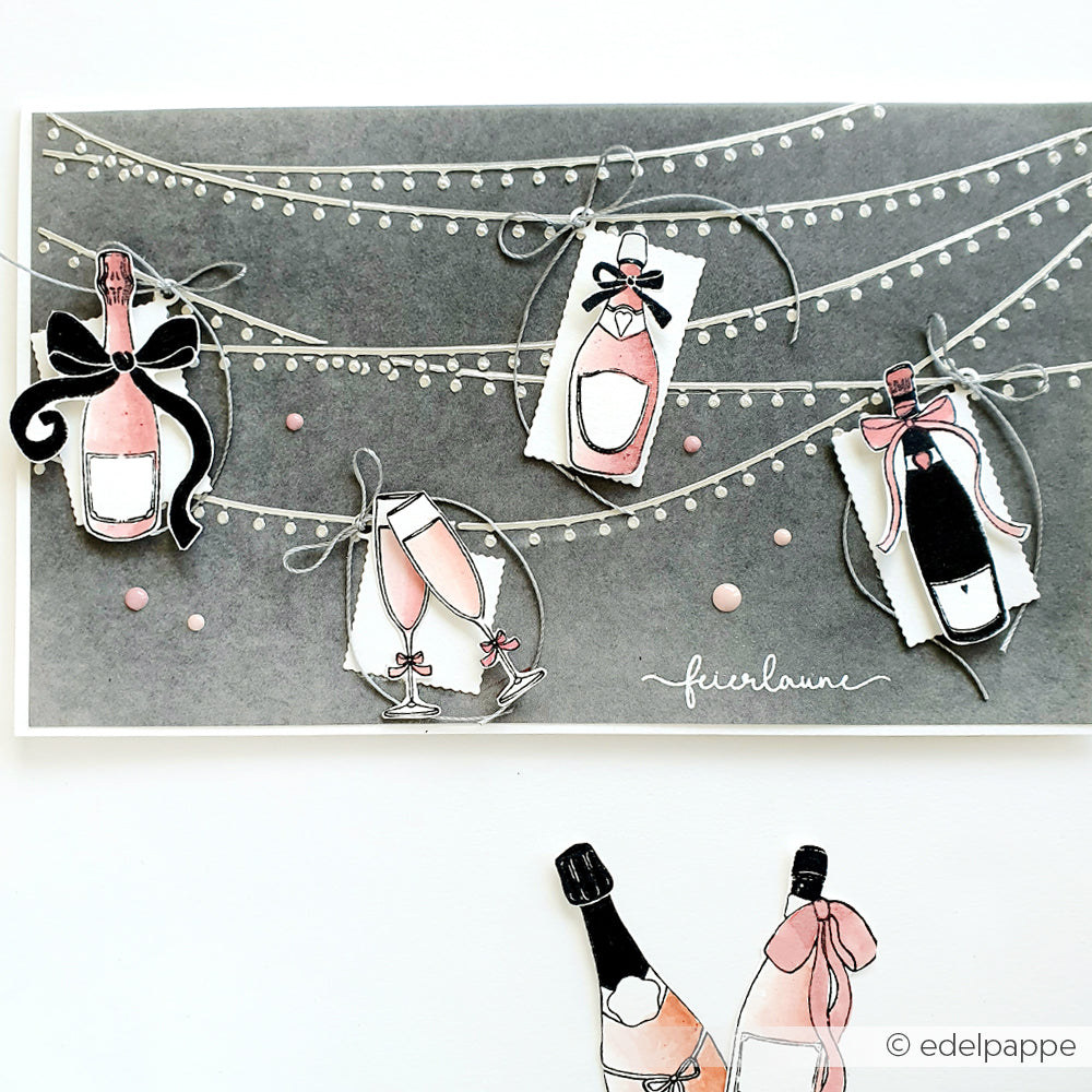 Handgezeichnete Sektflaschen und Gläser hängen an Lichterketten vor einem dunklen Hintergrund - ideal für festliche Karten, die mit Alexandra Renke Clear Stamps, Photopolymerstempeln und Ihren Lieblingsstempelkissen gestaltet wurden.
