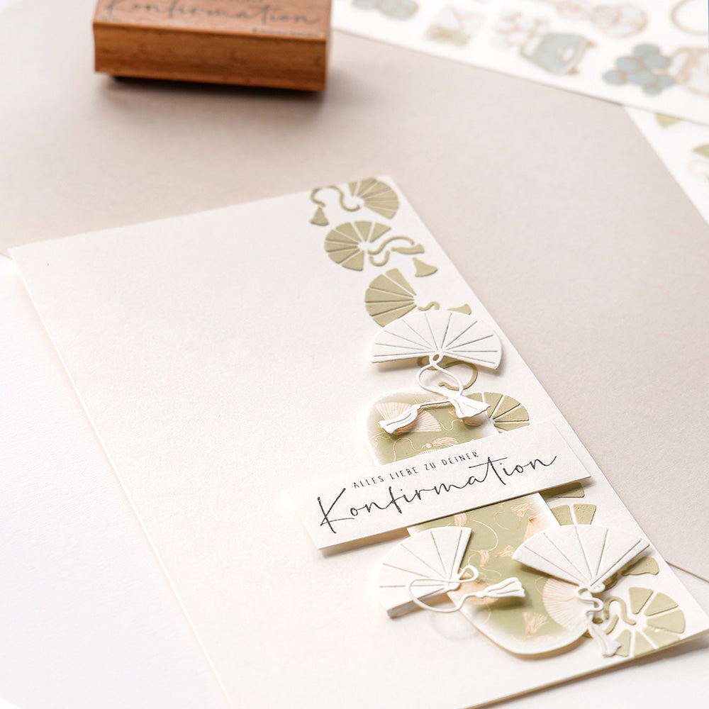 Eine handgefertigte Konfirmationskarte von Alexandra Renke mit Blatt- und Fächermotiven, die mit wiederverwendbaren Schablonen erstellt wurden, und dem Text "Alles Liebe zu deiner Konfirmation".
