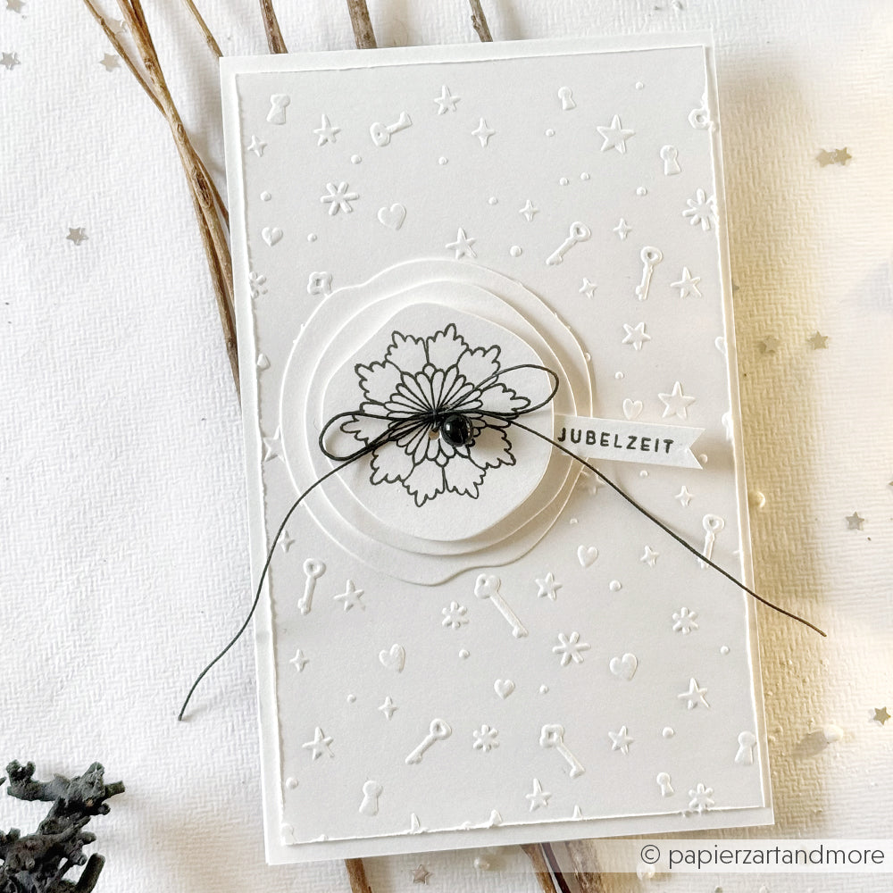 Weiße, geprägte Grußkarte von Alexandra Renke mit einer Blumenillustration, einer schwarzen Schleife und dem Schriftzug "Jubelzeit" - ideal zum Kombinieren mit Ihren Lieblingsmotiven von Clear Stamp oder Photopolymer Stempel.