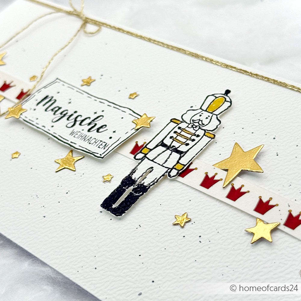 Eine handgefertigte Karte von Alexandra Renke mit einem Nussknacker, goldenen Sternen, roten Kronen und "Magische Weihnachten" - ideal für Papierprojekte oder Ihren Lieblings-Photopolymer-Stempel.