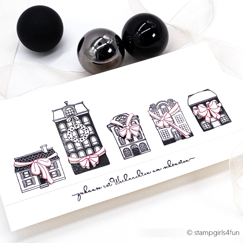 Eine festliche Karte von Alexandra Renke mit illustrierten Gebäuden mit Schleifen, die von schwarzen und silbernen Zierkugeln umrahmt werden - ideal für Papierprojekte oder zum Aufwerten von Details mit Clear Stamps.