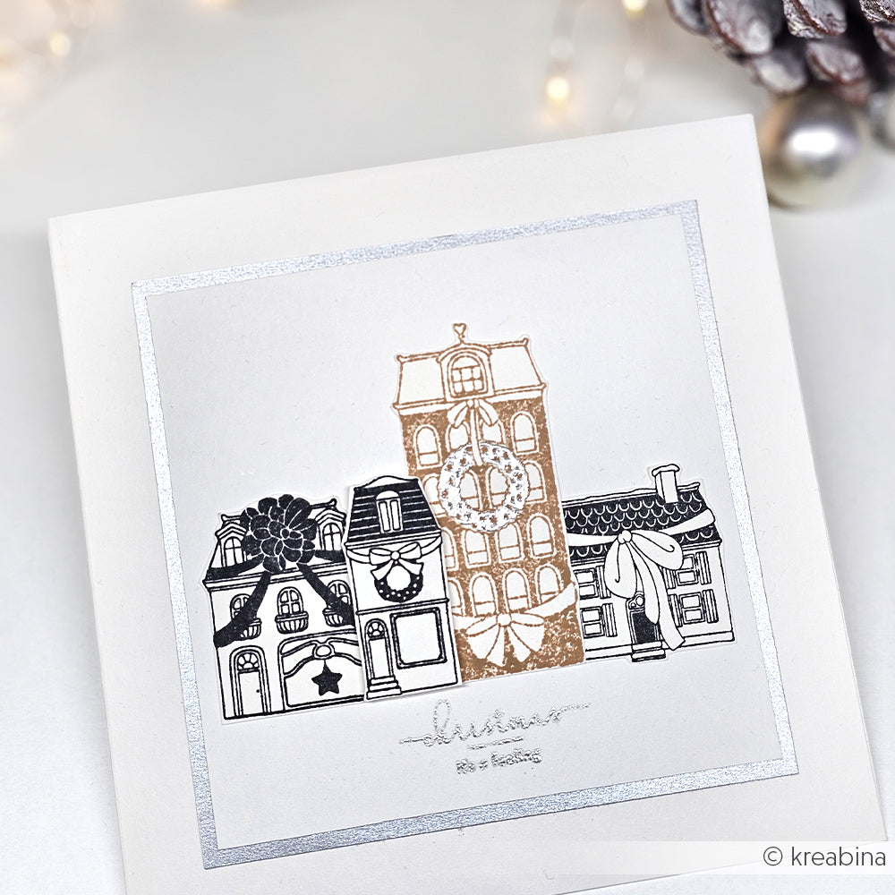 Eine festliche Karte von Alexandra Renke mit einer silbernen und goldenen Illustration von geschmückten Stadthäusern für die Feiertage, ideal für Ihre Papierprojekte oder in Verbindung mit Ihrem Lieblings-Klarsichtstempel.