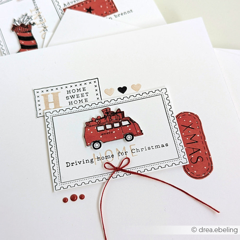 Handgemachte Weihnachtskarte von Alexandra Renke mit einem roten Lieferwagen und Geschenken auf dem Dach, festlichen Anhängern mit den Worten "Home Sweet Home" und "XMAS", hergestellt mit einem Klarsichtstempel für scharfe Weihnachtsdetails.