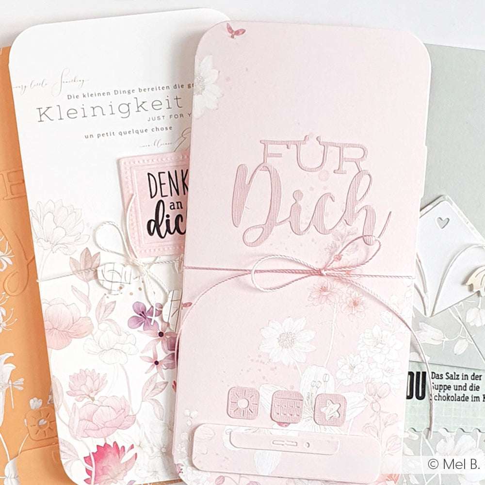 Drei pastellfarbene Blumengrußkarten von Alexandra Renke, jede mit deutschem Text und eine mit einer Schleife verziert, sind stilvoll übereinandergelegt und bilden ein elegantes Display.