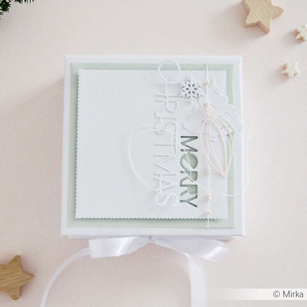 Quadratische weiße Weihnachtsgeschenkbox mit "Merry Christmas"-Text, Schleife, Sternenakzenten und einem stilvollen Briefmarkenrand Stanze von Alexandra Renke. Auf einem hellen Hintergrund - perfekt, um Ihren Weihnachtsgeschenken einen handwerklichen Touch zu verleihen.