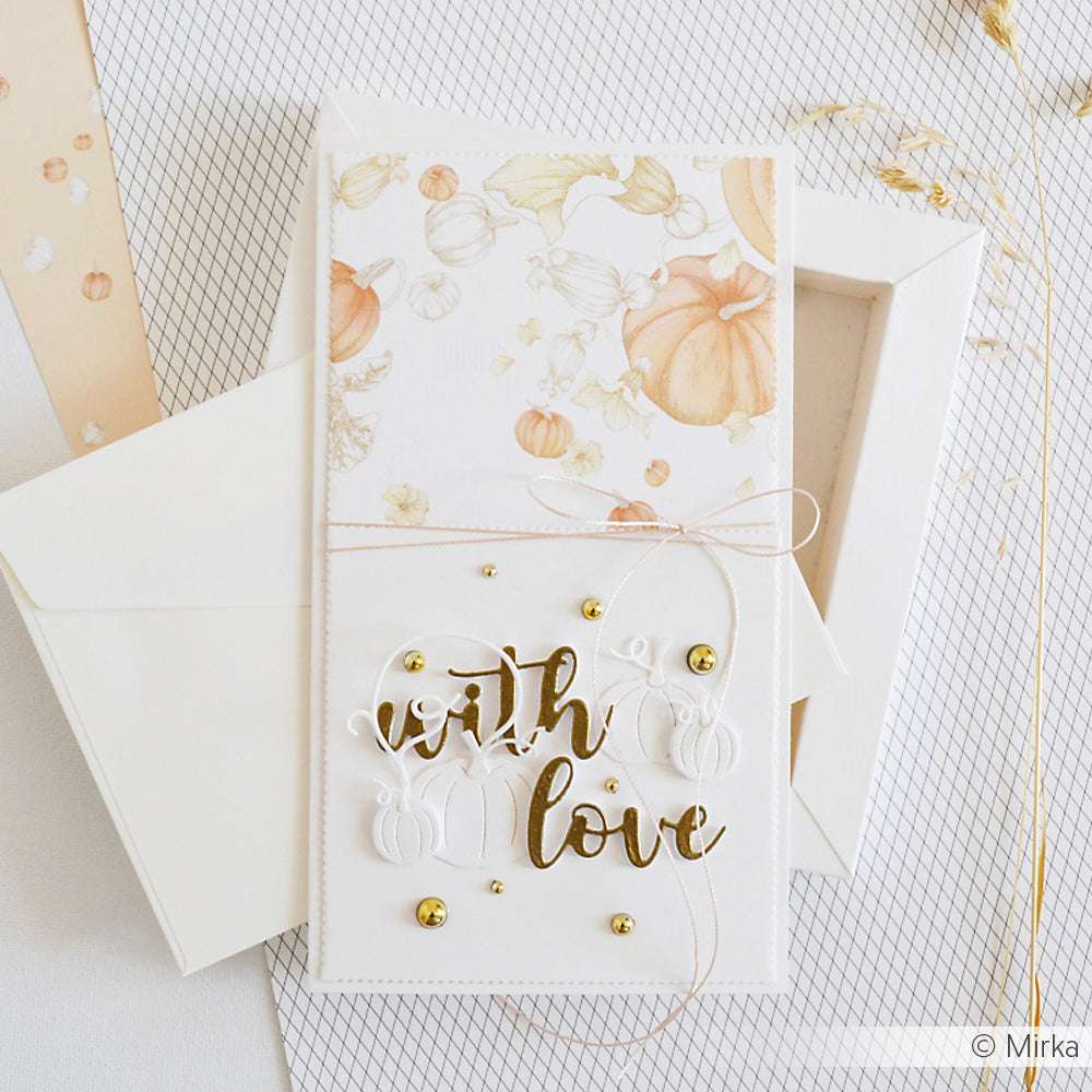Eine handgefertigte Karte von Alexandra Renke mit "With Love" in goldener Schrift, Kürbismotiven aus Stanzen für Designpapier, einer rosa Schnur und einem weißen Umschlag.