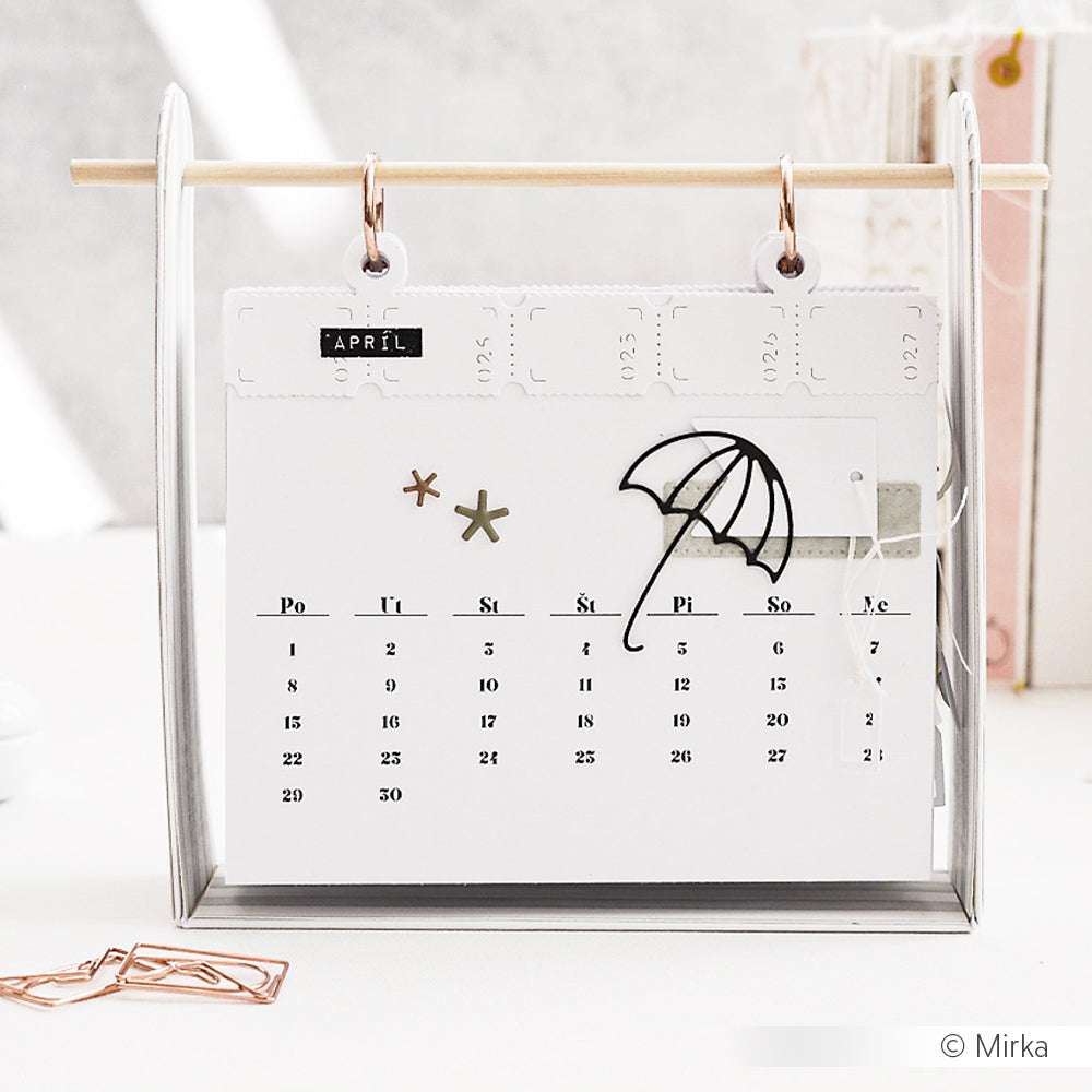 Minimalistischer April-Tischkalender von Alexandra Renke mit Motivstanze Regenschirm und Sternen, elegant präsentiert auf einem Holzständer.