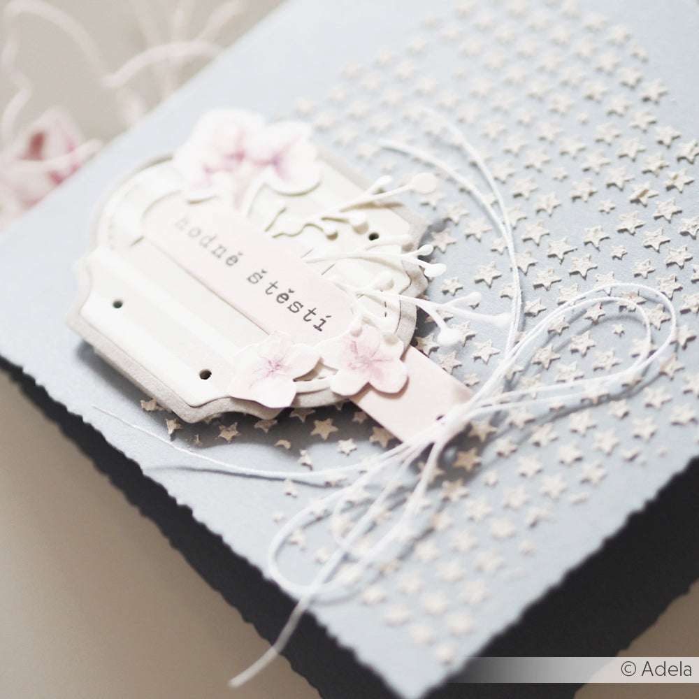 Eine handgefertigte Karte von Alexandra Renke mit geprägten Sternen, weißer Kordel, einer Motivstanze Etikett, rosa Blumen und tschechischem Text - perfekt für Designpapiere-Fans und Liebhaber einzigartiger Designs.