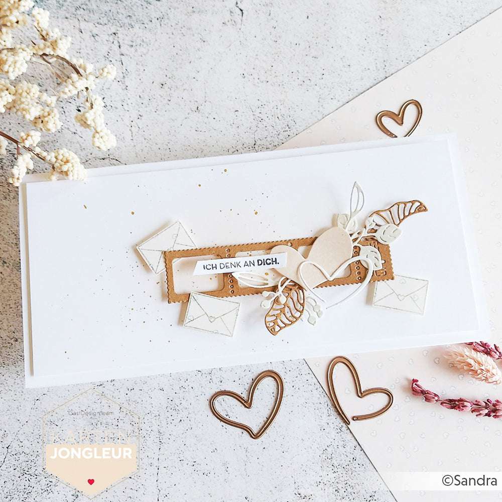 Eine handgefertigte Karte von Alexandra Renke, hergestellt mit Motivstanze, zeigt Herzen, Blätter, Umschläge und den deutschen Text "ICH DENK AN DICH" auf weißem Hintergrund.