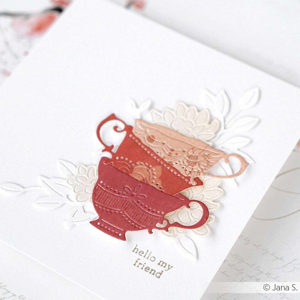 Zwei dekorative Teetassen aus Papier mit floralen Motiven, die mit einer Alexandra Renke Motivstanze hergestellt wurden, stehen auf einer weißen Karte mit der Aufschrift "Hallo, mein Freund".