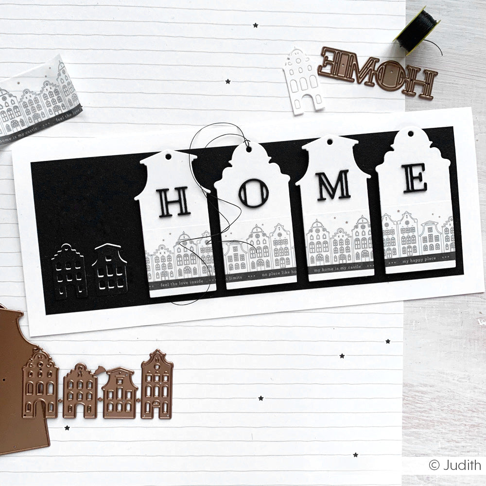 Handgefertigte Karte von Alexandra Renke mit schwarz-weißen Motivstanze Hausetiketten mit dem Schriftzug HOME über geprägten Häusern auf gefütterten Designpapieren, die einen charmanten, strukturierten Look ergeben.