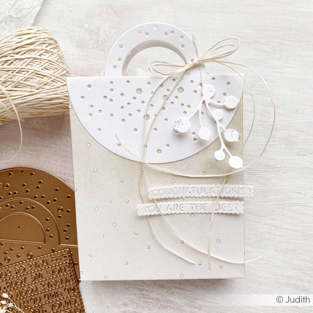 Eine weiße Tasche mit Kordel, hergestellt mit Alexandra Renke Motivstanze Tütengriff Schnee und DieCut Systemen für eine elegante Präsentation.