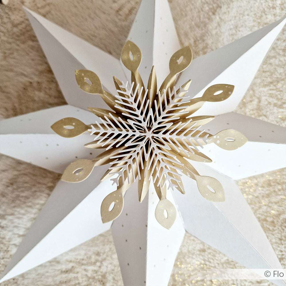 Sterndekoration aus weißem und goldenem Papier mit filigranen Ausstanzungen, erstellt mit der Alexandra Renke Motivstanze Rosette Schneeflocke, dargestellt auf einer strukturierten Oberfläche.