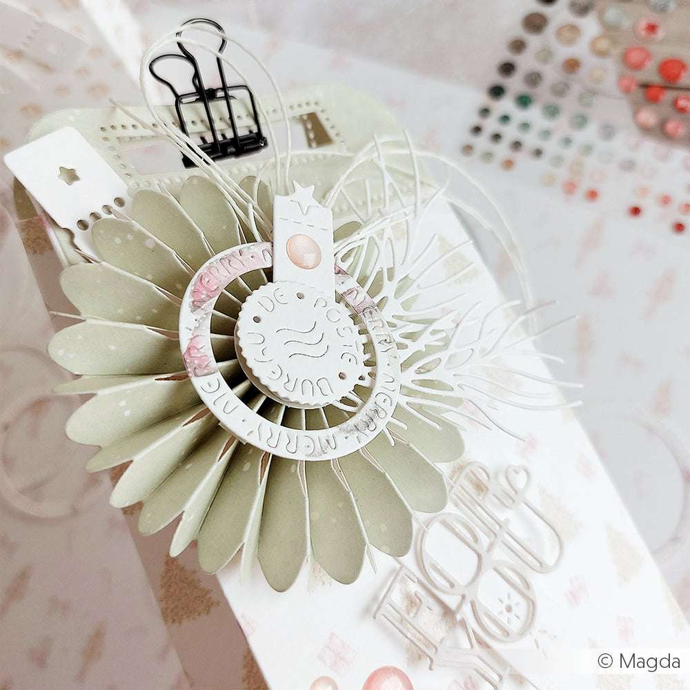 Nahaufnahme eines handgefertigten Geschenkanhängers aus Alexandra Renke Designpapier, mit geschichteten Papierblumen, gestanzten Formen aus der Motivstanze Rosette 8 und dekorativen Verzierungen.