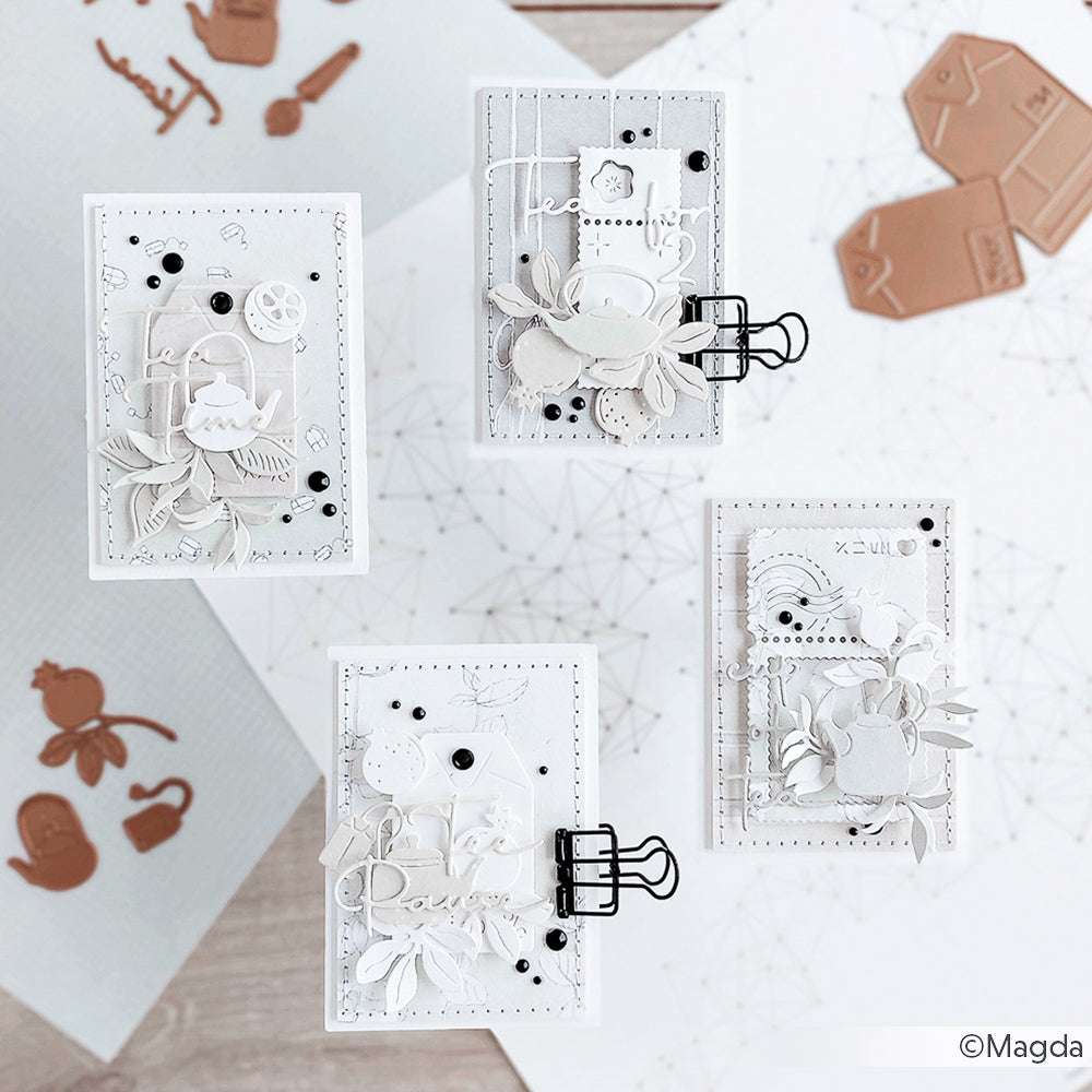 Vier aufwendig verzierte, weiße und graue handgefertigte Karten mit übereinanderliegenden Verzierungen und geometrischen Hintergründen, hergestellt mit Alexandra Renke Dies für Papierbasteln und einer Motivstanze Teebeutel-Etiketten für zusätzliche Details.