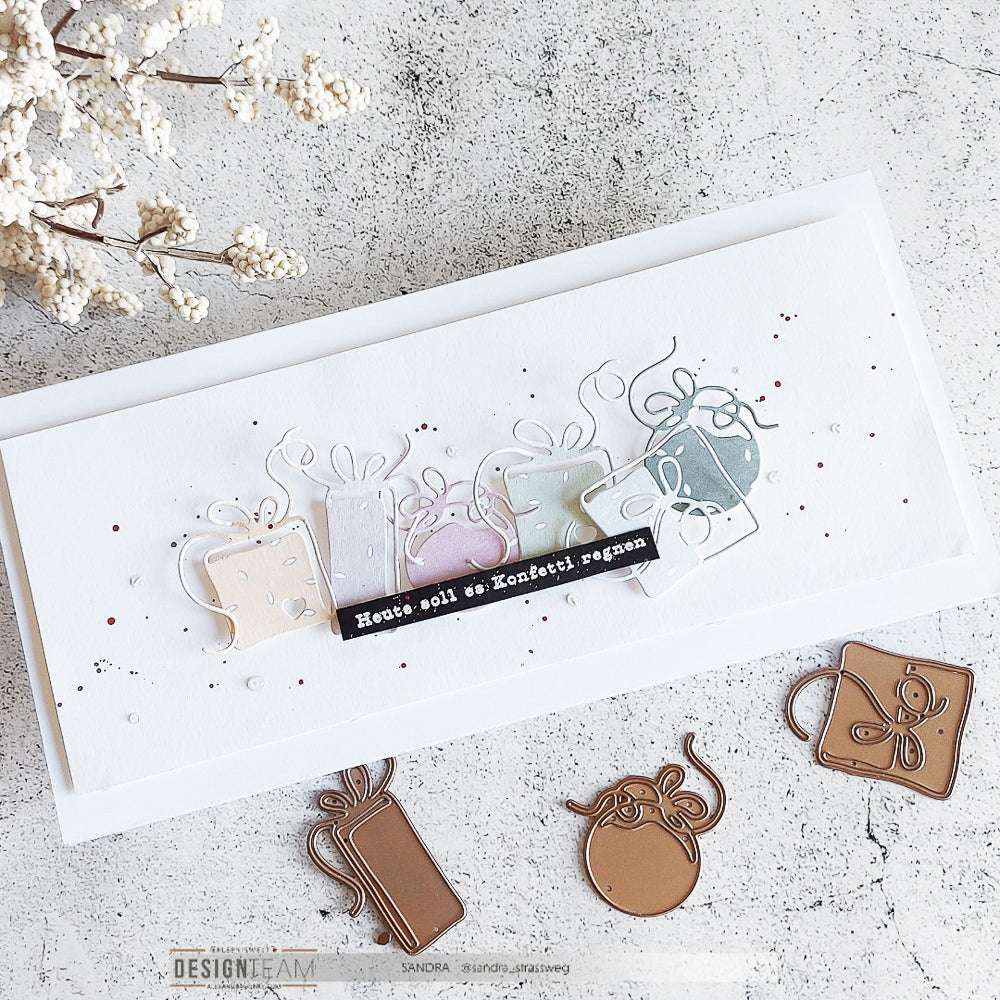 Handgefertigte Karte von Alexandra Renke mit pastellfarbenen Geschenkschachtelausschnitten, einer deutschen Botschaft und Geschenkeset Milano Dies. Metallische Motivstanze Akzente auf weißem Hintergrund.