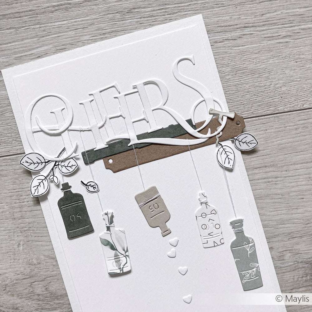 Handgefertigte Karte von Alexandra Renke mit "CHEERS", Flaschen, Blättern und Herzen in neutralen Tönen auf Weiß - hergestellt mit Stanzsystemen Dies für klare, detaillierte Akzente.