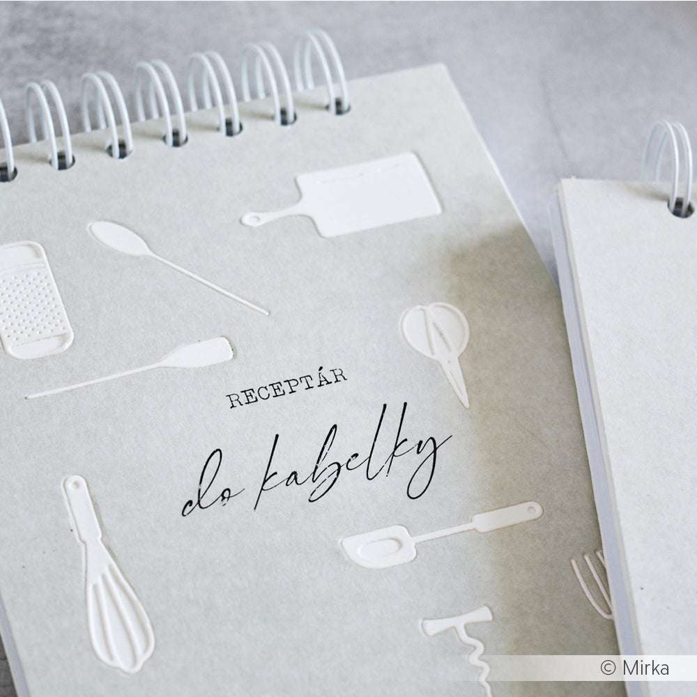 Ein spiralgebundenes Rezeptbuch von Alexandra Renke mit Abbildungen von Küchenutensilien aus dem Motivstanze Küchenutensilien-Set und dem Aufdruck "RECEPȚÁR do kabelky" auf dem Einband.