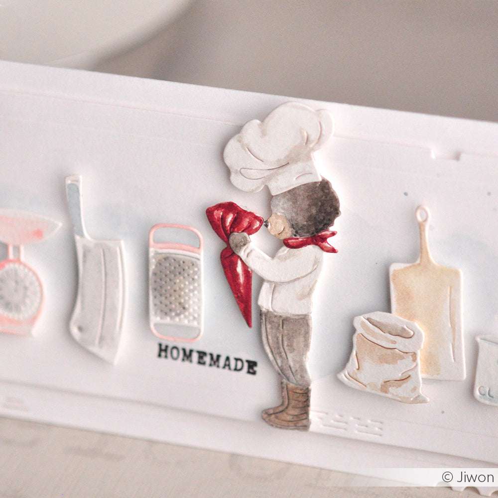 Eine Scherenschnittfigur eines kleinen Kochs mit Spritzbeutel, Küchenutensilien aus dem Alexandra Renke Küchenutensilien-Set und dem Text HOMEMADE. Ideal zum Basteln mit DieCut Systemen und 100% Stahl Stanzen.