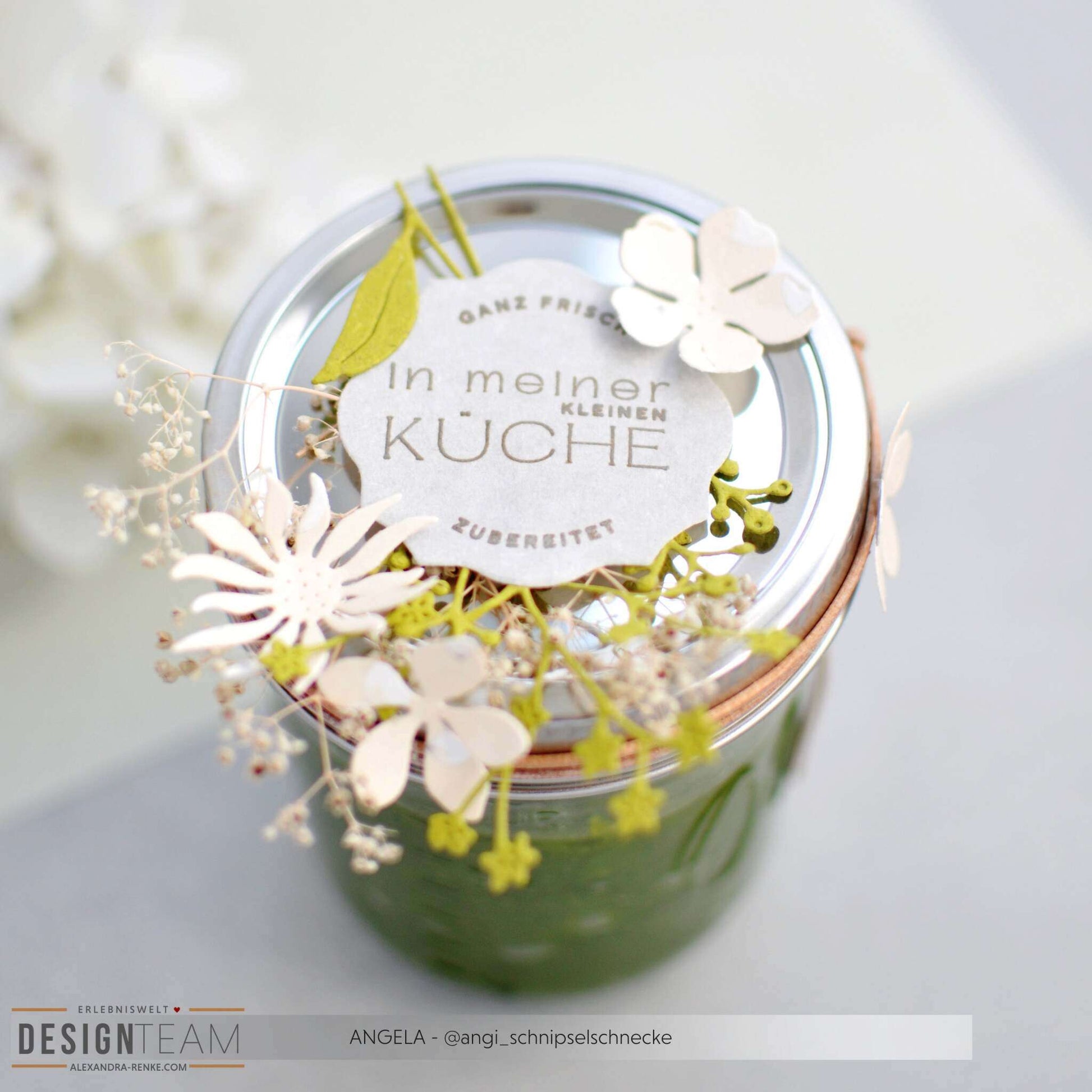 Glasgefäß mit der Aufschrift "In meiner kleinen Küche" und Papierblumen auf dem Deckel, von oben gesehen. Mit charmanten, kreativen Details aus Designpapieren von Alexandra Renke.