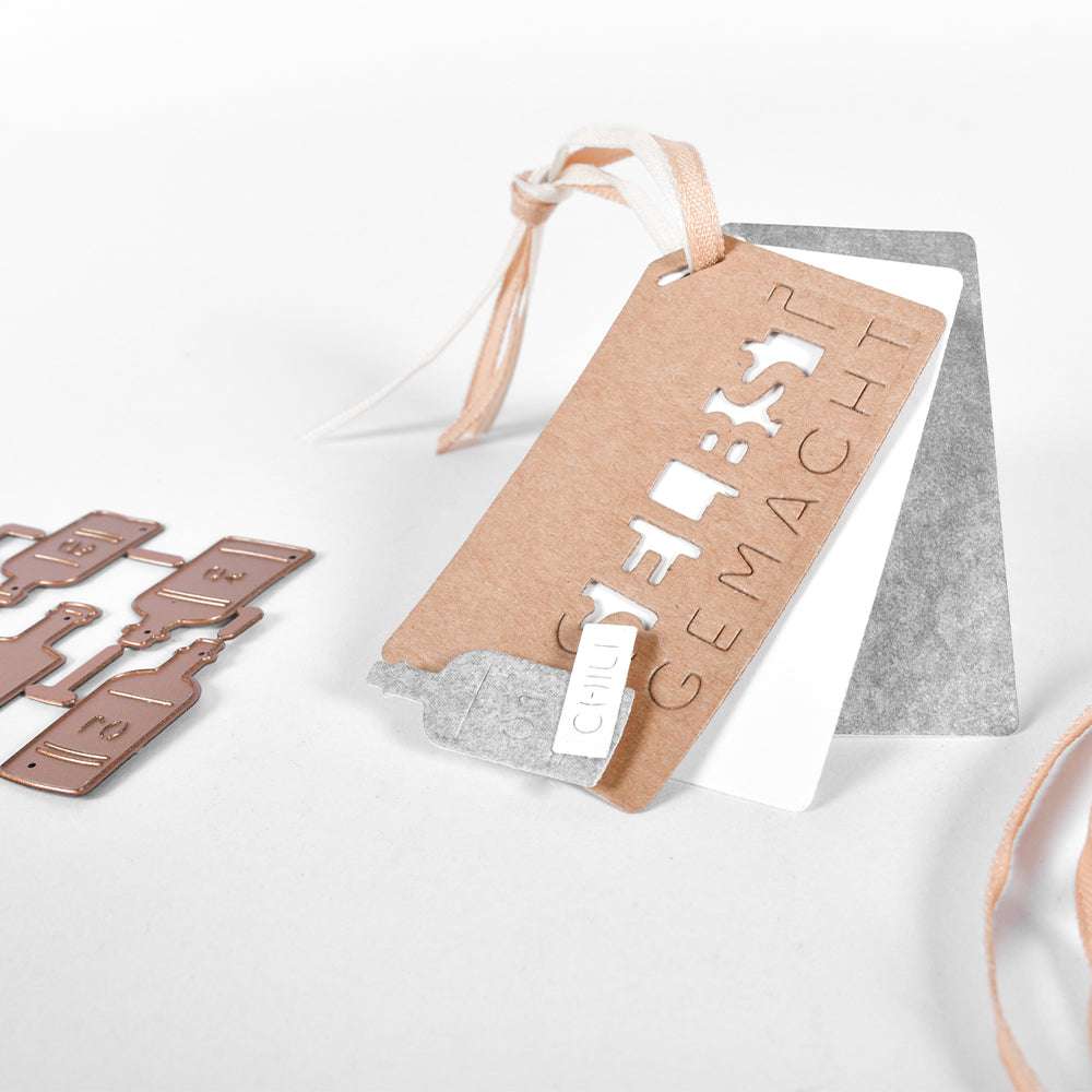 Braun-weiße Anhänger mit Bändern von Alexandra Renke, hergestellt aus Designerpapier. Auf einem ist "Selbst gemacht" ausgestanzt. Perfekt für kreative Projekte mit Stanzsystemen oder einer Winkelschnitt Tag Stanze, abgebildet auf einer weißen Fläche.