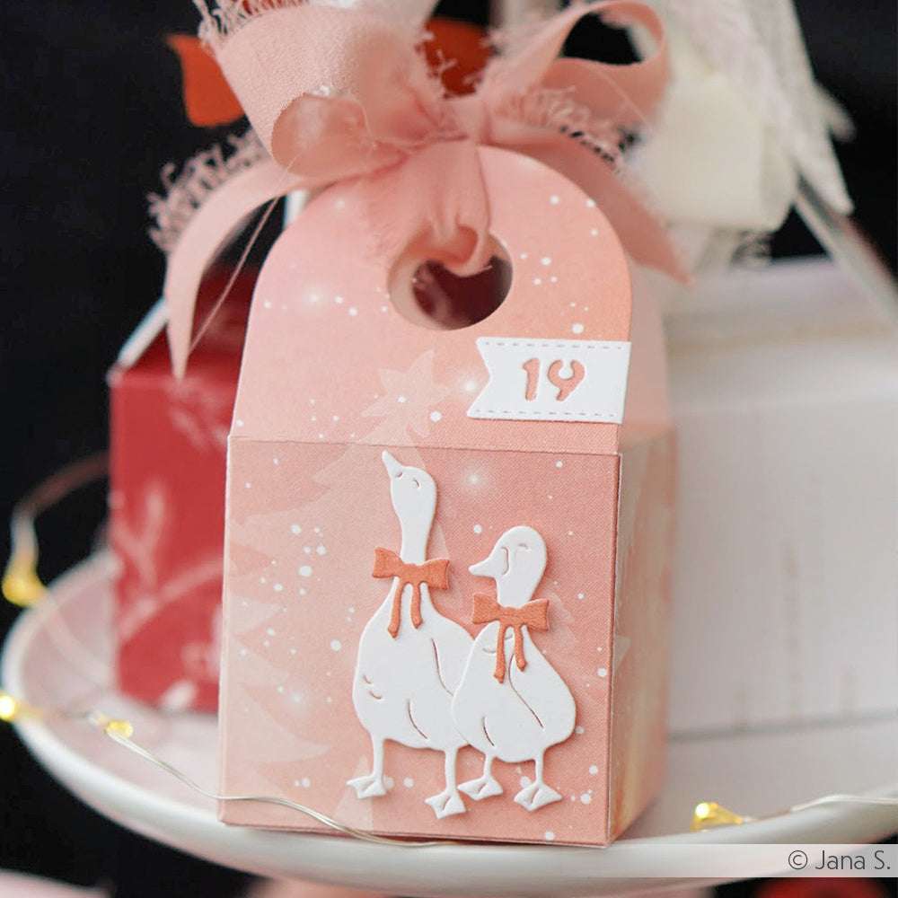 Rosa Geschenkbox von Alexandra Renke mit zwei weißen Gänsen mit roter Schleife, einer großen rosa Schleife und einem "19"-Anhänger - ideal für Feiern oder als Akzent für Ihr Projekt mit Designpapieren oder Motivstanze Zahlen.