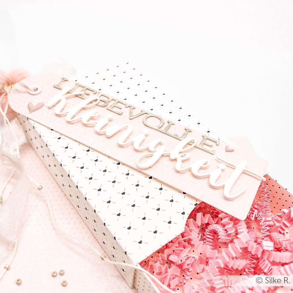Alexandra Renke Geschenkbox mit rosa Fetzen, einem gemusterten Deckel und einem "LIEBEVOLLE KLEINIGKEIT"-Anhänger - ideal zum Ausstellen von Stanzen für Designpapier oder zum Gestalten mit der Motivstanze Großes Etikett.