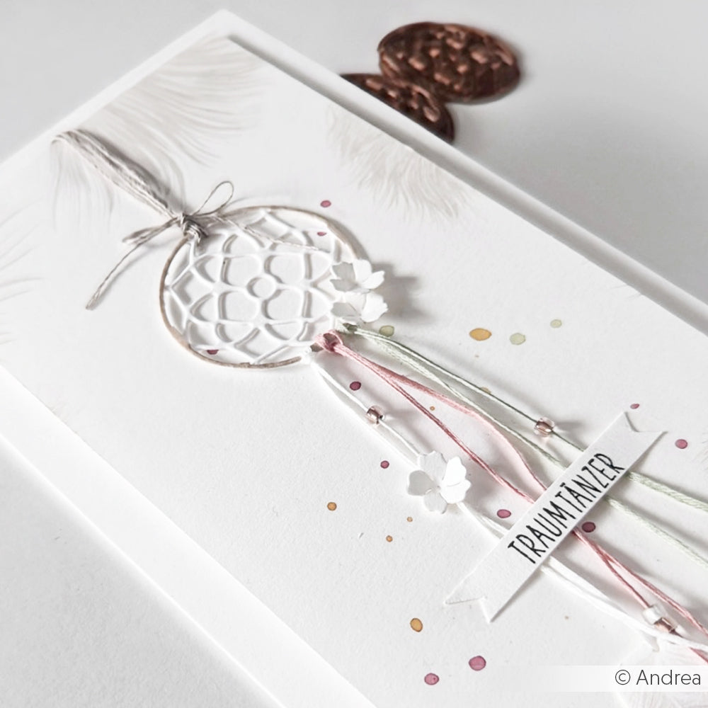 Eine handgefertigte Karte von Alexandra Renke mit einem Traumfänger-Motiv, pastellfarbenen Bändern und einem "TRAUMFÄNGER"-Label auf weißem Hintergrund, hergestellt mit Motivstanze Ornament und hochwertigen Designpapieren für ein elegantes Finish.