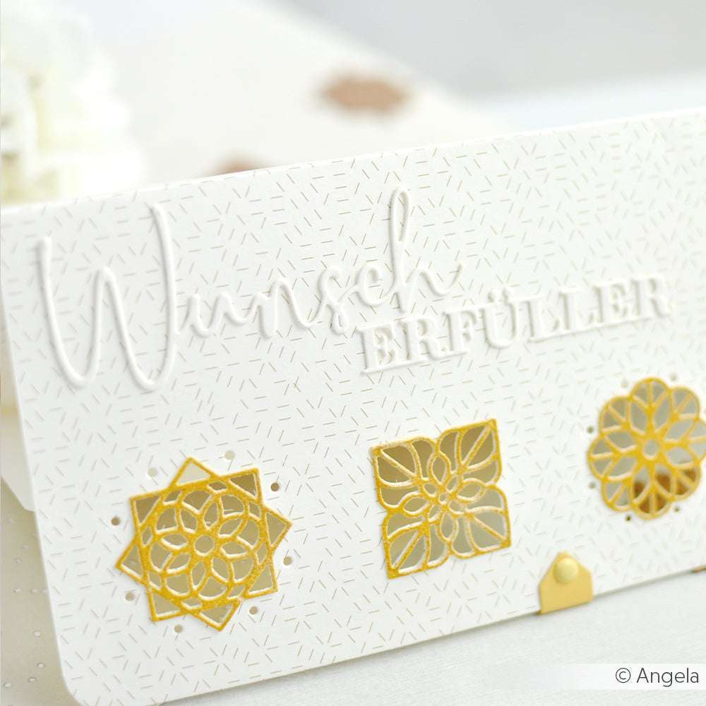 Weiße Karte von Alexandra Renke mit dem Text "Wunsch Erfüller" und drei goldenen geometrischen Blumen am unteren Rand, hergestellt mit Designpapier Stanzsystem und Motivstanze Ornament mit Kontur Dies für ein präzises, elegantes Aussehen.