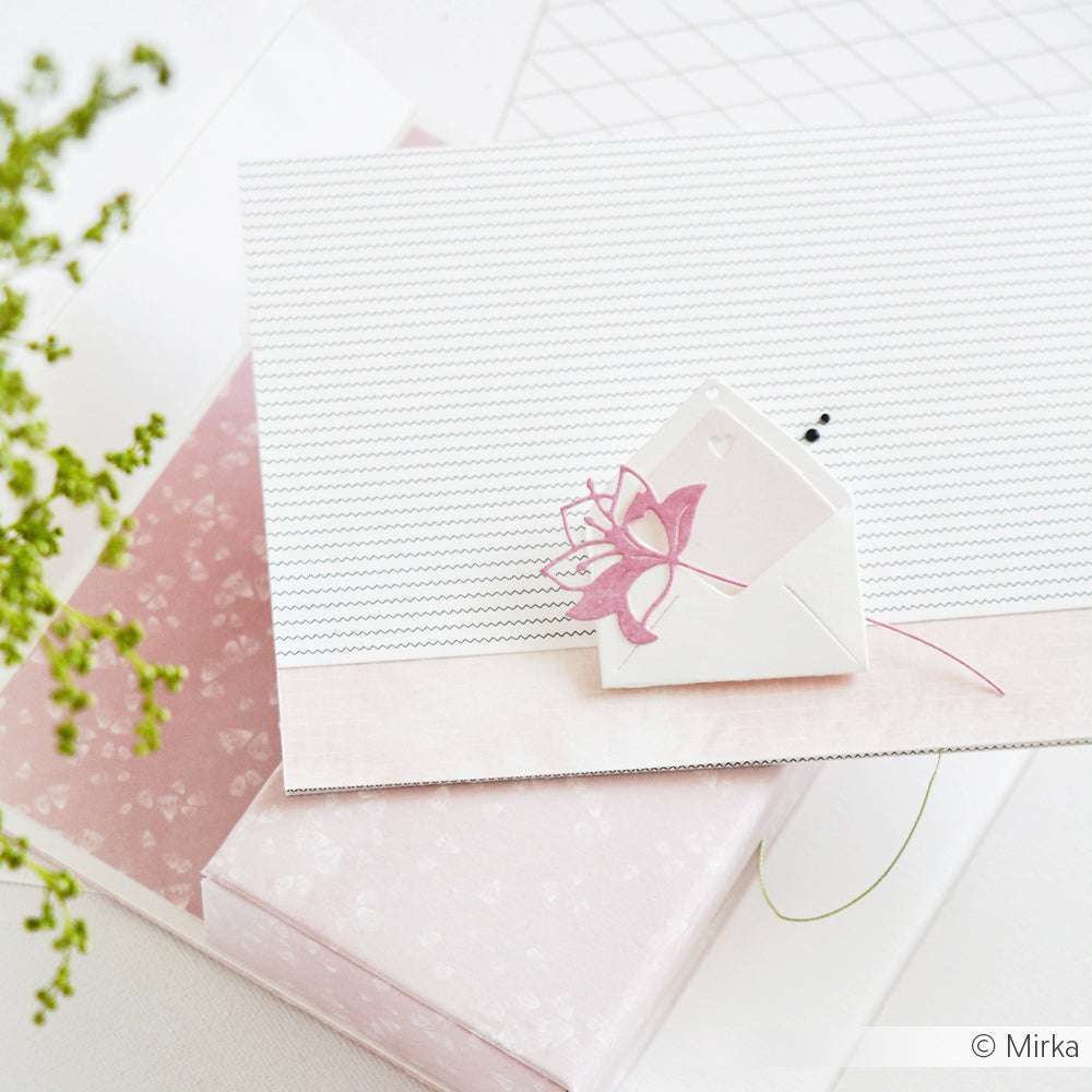 Grußkarte von Alexandra Renke mit einem kleinen weißen Umschlag, hergestellt mit DieCut Systemen und Designpapieren, mit einer rosafarbenen Blume auf einem rosa und weiß gemusterten Karton.