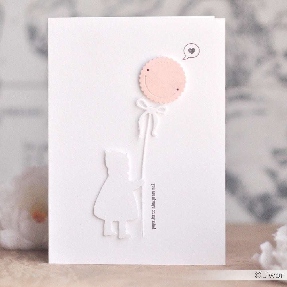 Die Silhouette eines Kindes, das einen rosafarbenen Luftballon mit einem Smiley-Gesicht und einer Herz-Sprechblase in der Hand hält - ideal für Alexandra Renke Designpapiere oder zum Basteln mit Stanzsystemen.