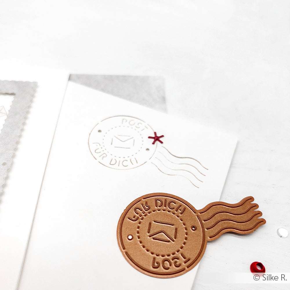 Eine weiße Karte von Alexandra Renke mit einem runden, geprägten "Post für dich"-Siegel und einer passenden DieCut Systeme-Verzierung.